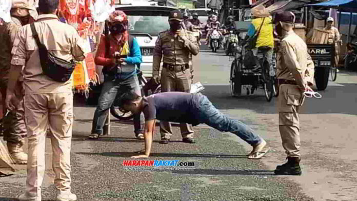 Petugas Dinas Satpol PP Kota Banjar saat memberikan sanksi push up kepada warga yang tidak mengenakan masker. Foto: Muhlisin/HR.