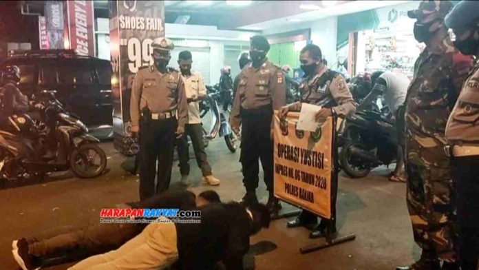 Operasi Yustisi akhir pekan, Tim Satgas Penindakan saat memberikan sanksi kepada para pelanggar protokol kesehatan, Sabtu (08/11/2020) malam. Foto: Muhlisin/HR.