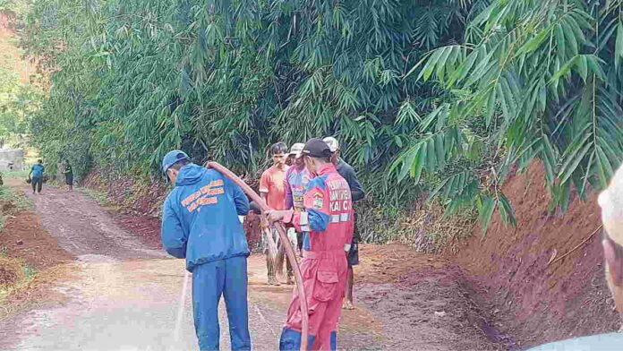 Bahayakan Pengendara Motor, Petugas Damkar Siram Material Tanah di Jalan di Dayeuhluhur Ciamis